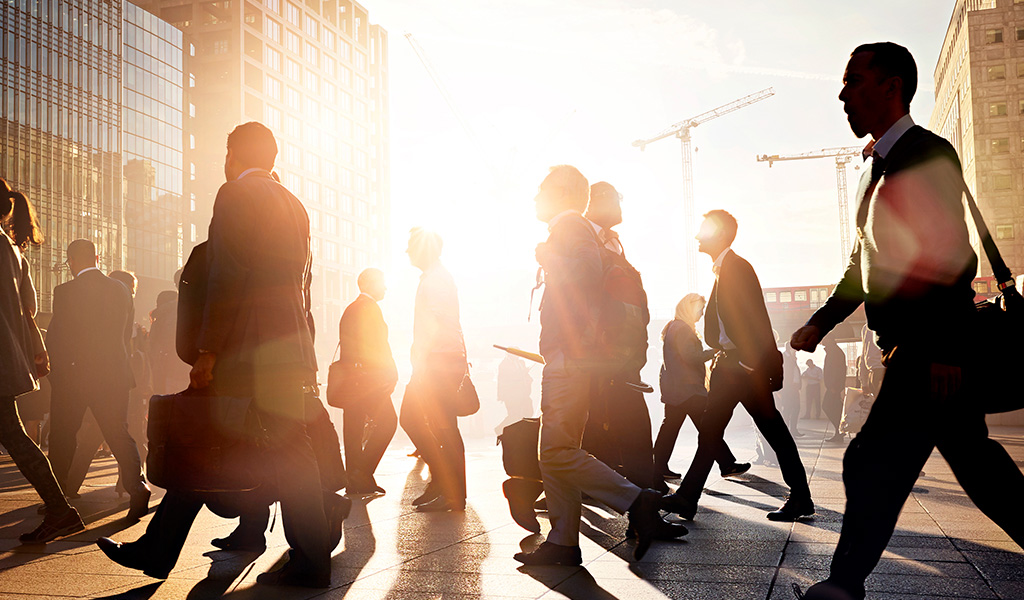 business people walking downtown at sunrise